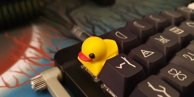 A rubber duck keycap on the top left of a keyboard. Quack! 🦆